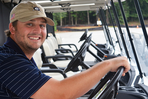 UGA Golf Course employee sits in a golf cart.