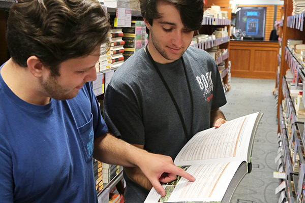 UGA Bookstore employee helps student with a textbook.