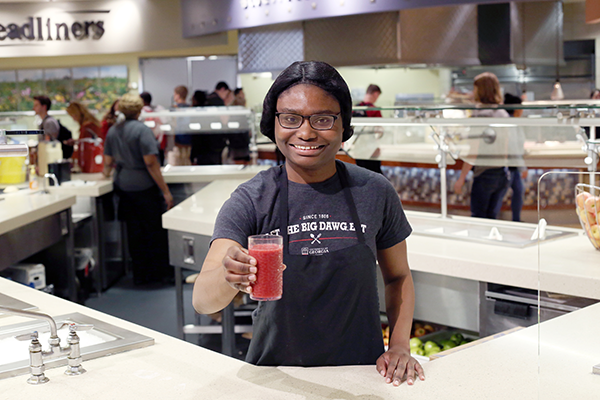 UGA Dining employee hand out a smoothie.