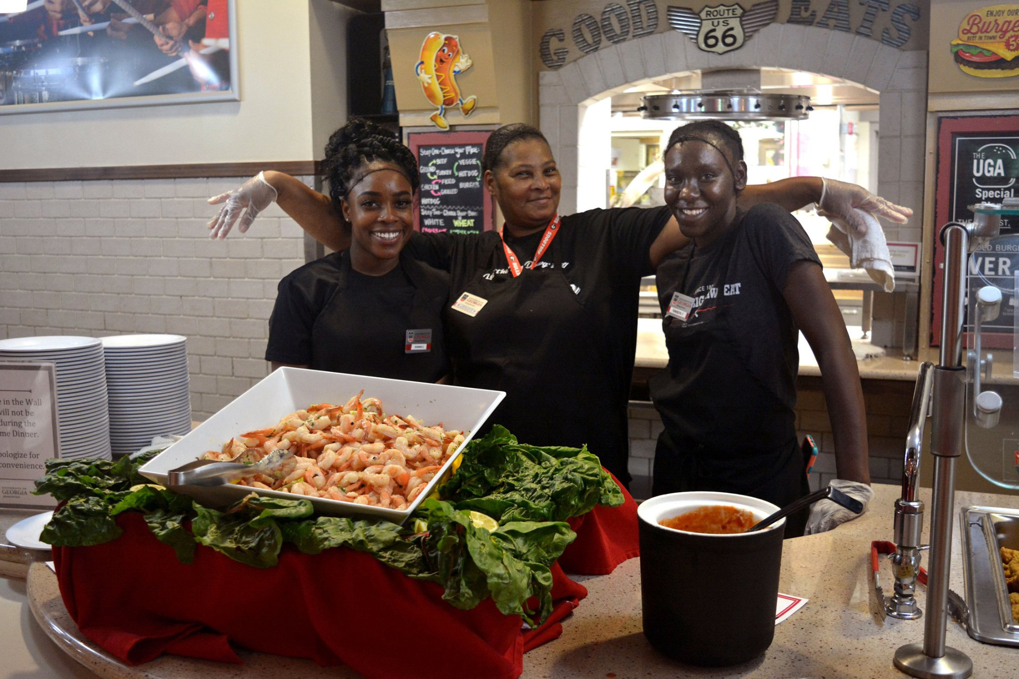 An team member hands a customer a burger and fries.