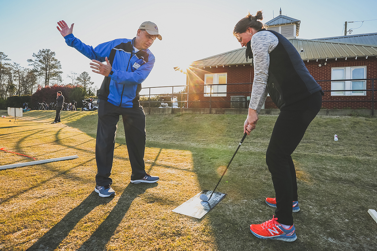 A golf team member fills a basket of balls for the range.