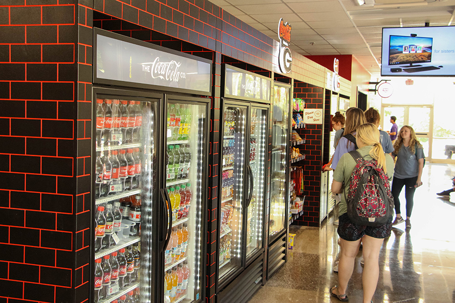 Vending Service's Campus Market Express location with a wall of Coke products and students in line.