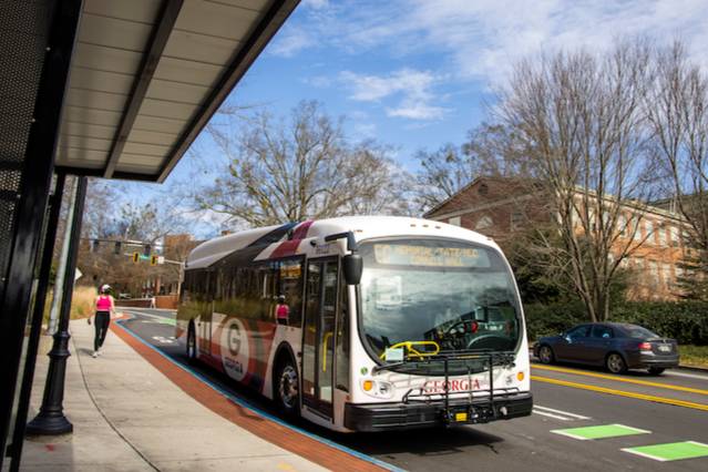 a uga bus at a bus stop