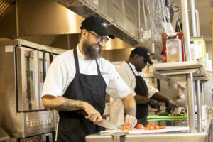 Dining Services Chef Robert Clark cuts a tomato in the kitchen at Oglethorpe Dining Commons