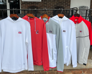 Golf pullovers with University of Georgia logo hanging on a clothing rack outside
