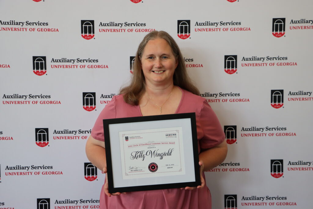 Photo of Kelly Wingfield holding a framed certificate