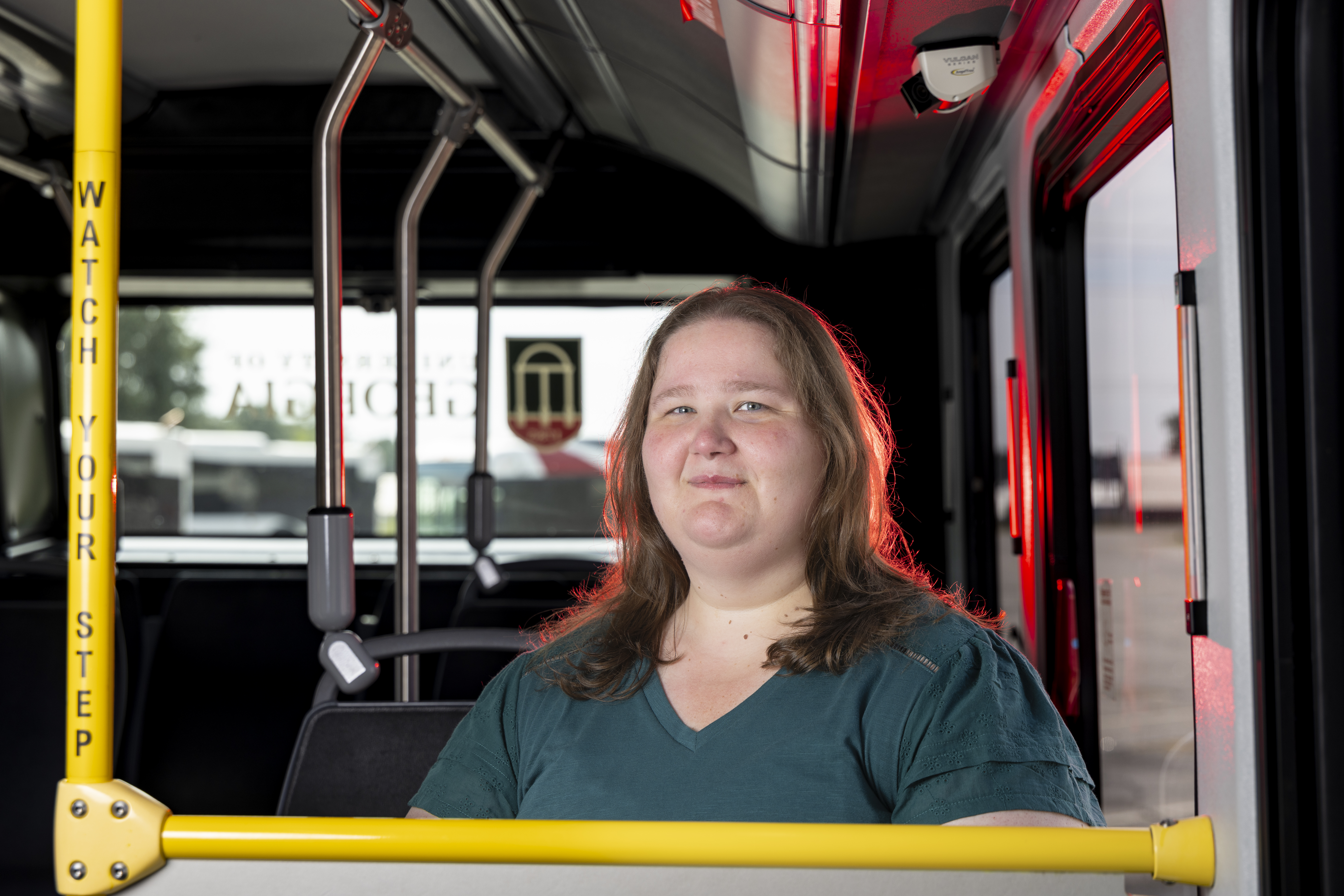 Portrait of Katie Scoggins, events planner for Transportation and Parking Services, inside a bus at the Riverbend Campus Transit Facility.
