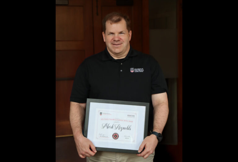 Photo of Mark Reynolds holding a framed certificate