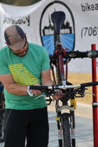 A man services the brakes on a bicycle
